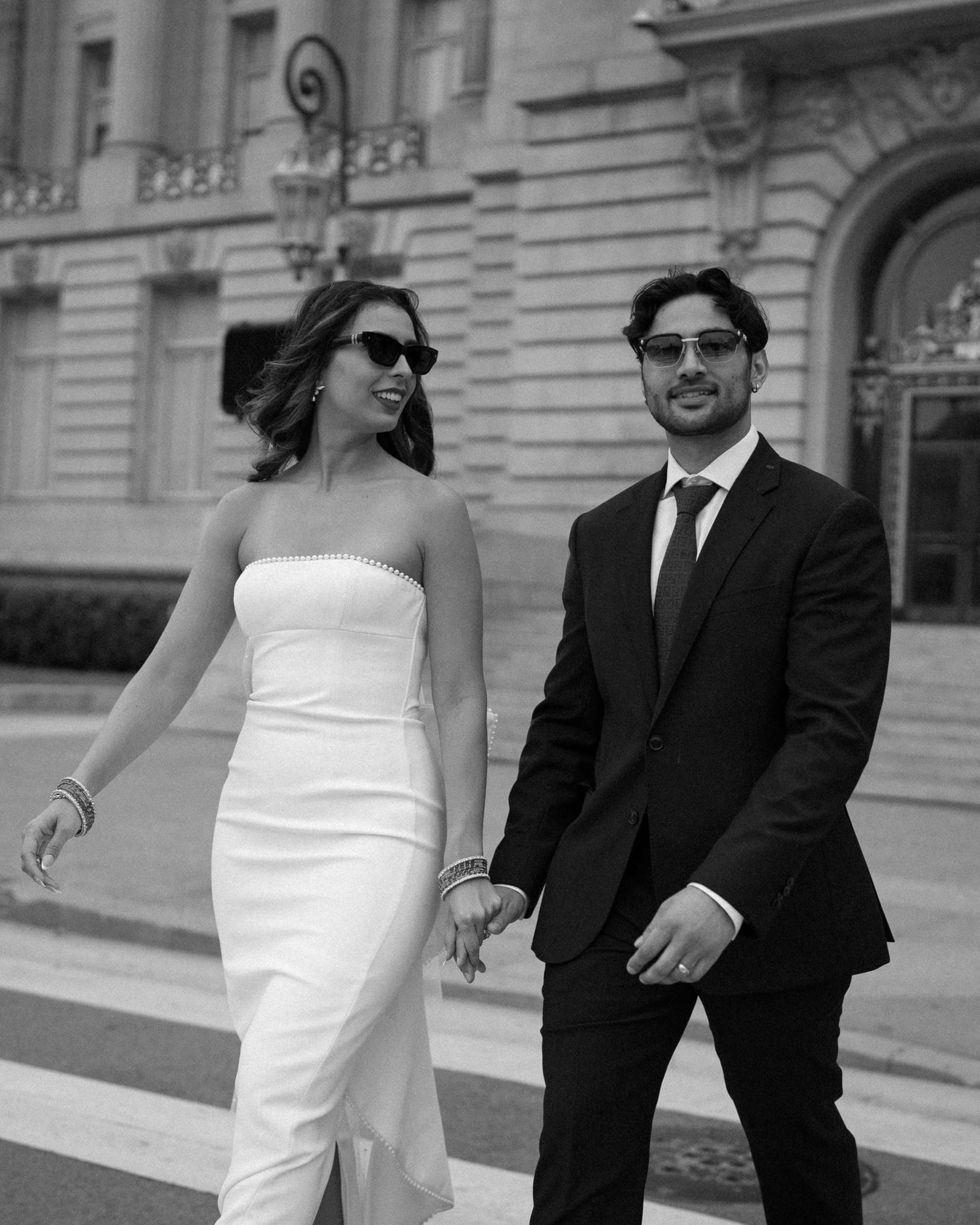 Bishal and Anna walking hand in hand, in black and white
