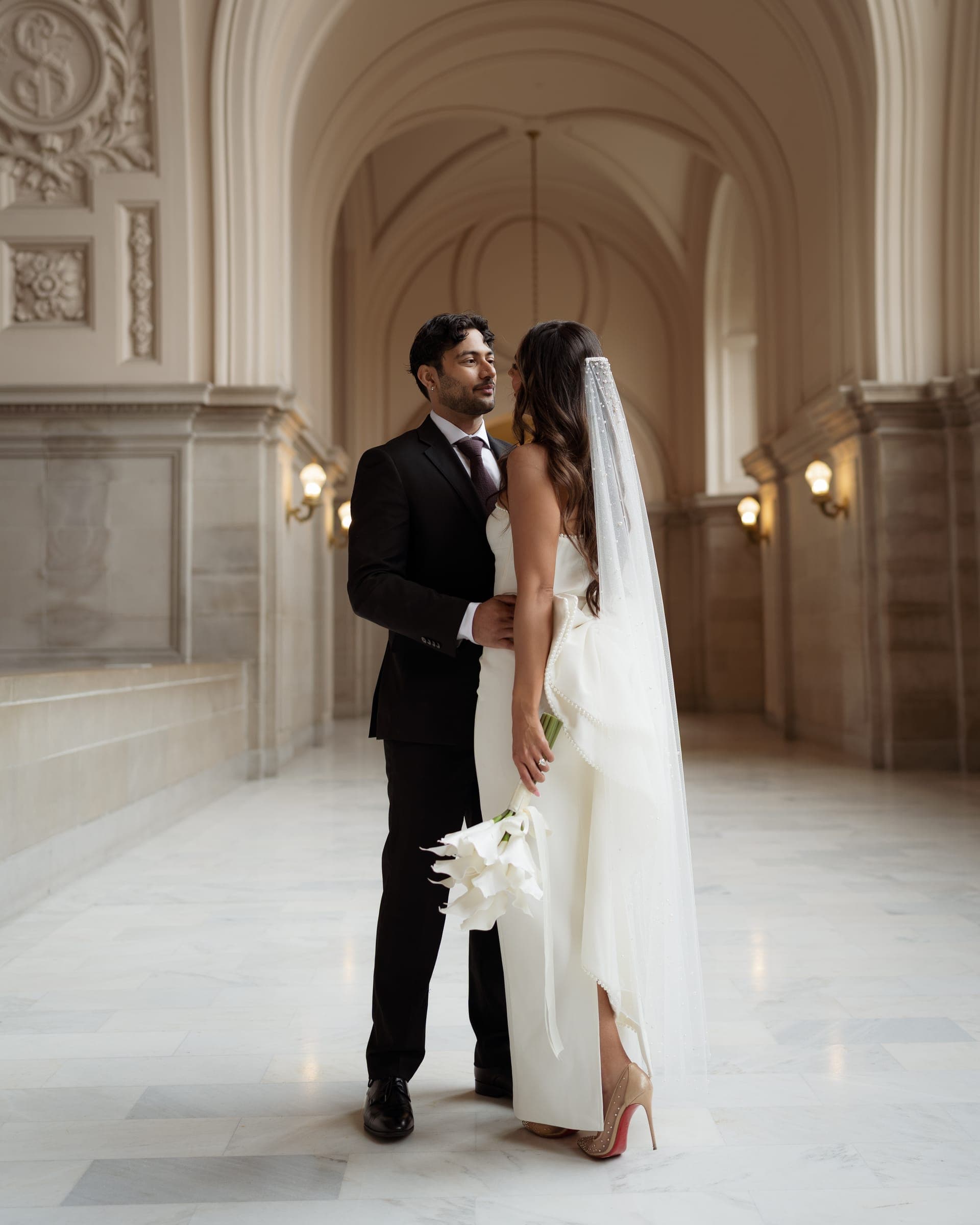 Bishal and Anna embracing in a marble corridor