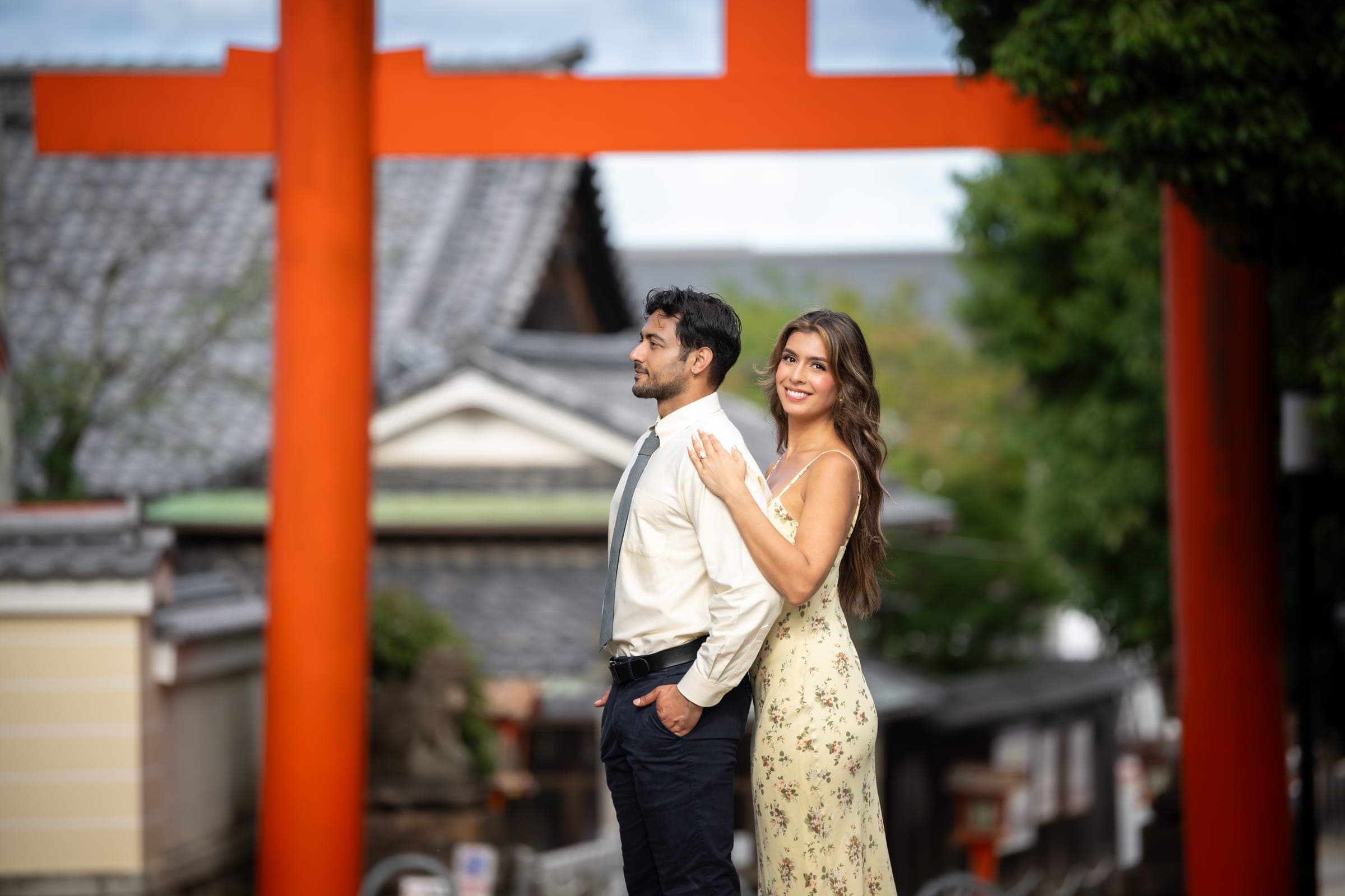 Bishal and Anna beneath a vermilion torii gate in Kyoto
